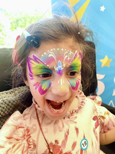 Creating memorable moments with beautiful face painting at a children's birthday party.